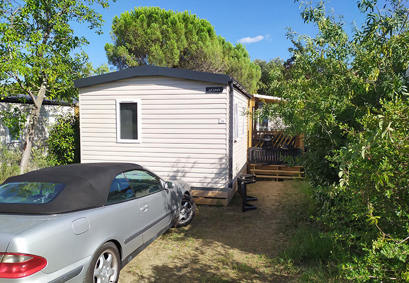 outside of Compact mobile home with parking space